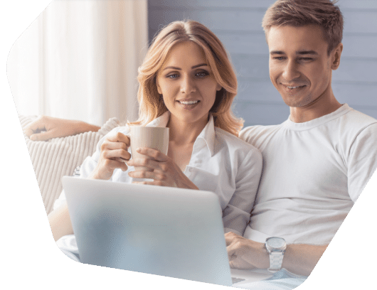 Happy couple smiling while browsing on a laptop